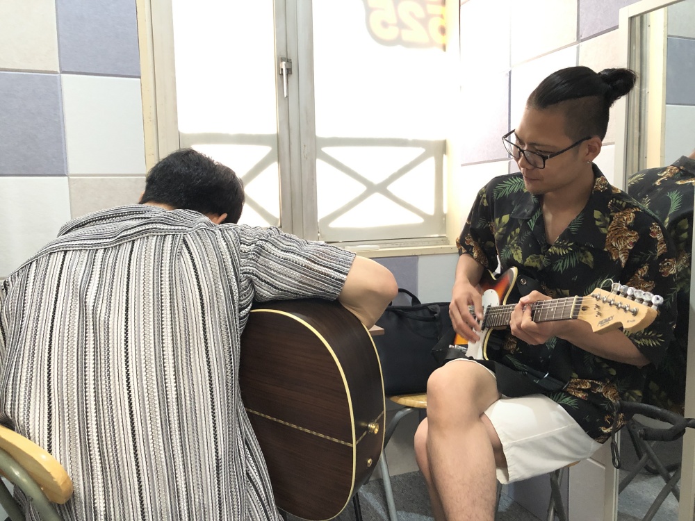 Guitar instructor Sun Sang teaching a student in Higashi-Osaka